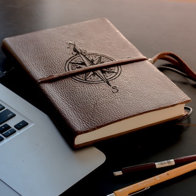 compass-theme-colton-sturgeon-N4fdQbMJ0nI-unsplash-400 Image of a leather notebook with a compass on it