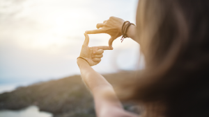 a woman's hands forming a frame to look through